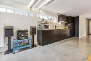 a large kitchen with a counter and a microwave at Cosy art studio near station with bikes and garden in Ghent