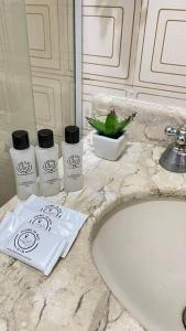 a bathroom counter with three products on a sink at Apartamento Copanema Subway Family HIR 27 in Rio de Janeiro