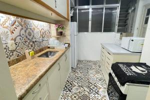 a small kitchen with a sink and a refrigerator at Apartamento Copanema Subway Family HIR 27 in Rio de Janeiro