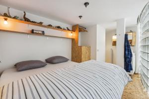 een slaapkamer met een bed met 2 kussens erop bij Cosy art studio near station with bikes and garden in Gent