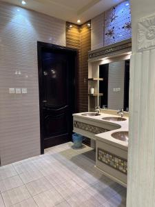uma casa de banho com 2 lavatórios e um espelho grande em استراحة وشاليه وقاعة السلطانه رجال em Al-Salam