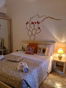 ジャルディーニ・ナクソスにあるB&B fragranza di siciliaのベッドルーム1室(壁に花を飾ったベッド1台付)