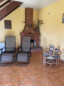 uma sala de estar com uma mesa e cadeiras e uma lareira em Chácara Vista para Represa em Mogi das Cruzes