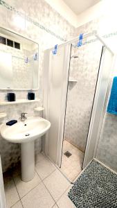 ein weißes Badezimmer mit Waschbecken und Dusche in der Unterkunft SeaView Fish2 in Lignano Sabbiadoro