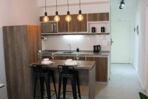 cocina con mesa de madera y 2 taburetes en BOLI0210 Moderno Oasis en San Telmo en Buenos Aires