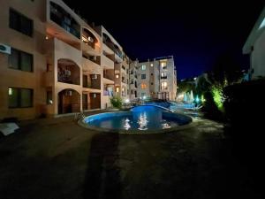 uma piscina no meio de um edifício à noite em Тристаен Апартамент- em Sveti Vlas