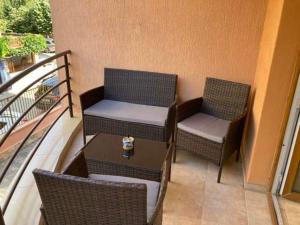 Duas cadeiras e uma mesa numa varanda em Тристаен Апартамент- em Sveti Vlas