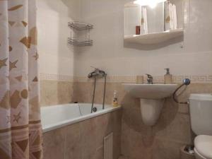 uma casa de banho com uma banheira, um lavatório e um WC. em Тристаен Апартамент- em Sveti Vlas