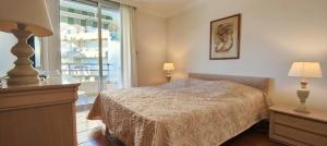 a bedroom with a bed and a window at 50 m cocoon of Love with a common shared pool in Saint-Raphaël