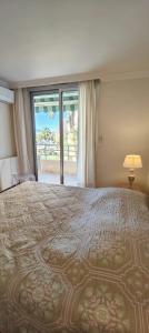 a bedroom with a large bed with a large window at 50 m cocoon of Love with a common shared pool in Saint-Raphaël +7 photos