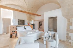 1 dormitorio con 1 cama, mesa y sillas en Masseria Longa Boutique Hotel, en Otranto