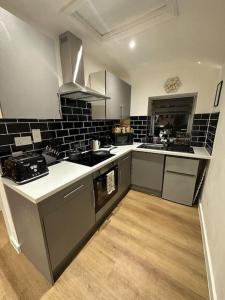 a kitchen with white and black tiles on the wall at The Hive - Cosy Studio in Wells City Centre in Wells