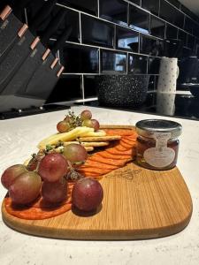 a cutting board with fruit and vegetables on a counter at The Hive - Cosy Studio in Wells City Centre in Wells