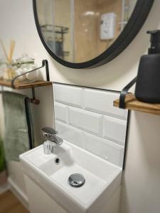 a bathroom with a white sink and a mirror at The Hive - Cosy Studio in Wells City Centre in Wells