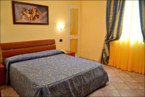 a bedroom with a bed and a painting on the wall at Hotel Anfora in Capoliveri