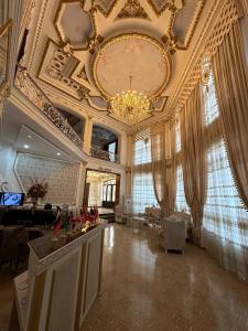 a large living room with a ceiling with a chandelier at EMIRS GARDEN Residence in Bukhara