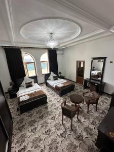 a large room with two beds and a chandelier at EMIRS GARDEN Residence in Bukhara