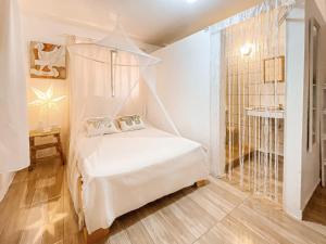 a bedroom with a white bed with a canopy at La Hacienda Hostel in Las Galeras