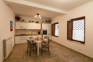 - une cuisine et une salle à manger avec une table et des chaises dans l'établissement Coppito Apartment, à Coppito