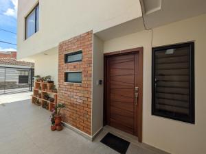 a house with a wooden door and a brick wall at Casa Crema in Cuenca