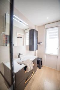 a bathroom with a sink and a mirror at Le Central Vue Mer Clim Plage 2min Cosy Confort - Jetservices Conciergerie in La Grande-Motte