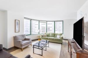 a living room with a couch and a tv at ENVITAE 3BR Luxury Corner Loft with Navy Pier Views in Chicago