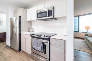 a kitchen with a stainless steel stove and a microwave at ENVITAE 3BR Luxury Corner Loft with Navy Pier Views in Chicago
