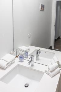 a white bathroom with a sink and a mirror at ENVITAE 3BR Luxury Corner Loft with Navy Pier Views in Chicago
