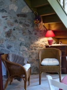 a room with two chairs and a table with a lamp at Gite d'Appy in Les Cabannes