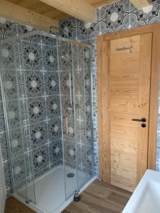 um chuveiro com uma porta de vidro na casa de banho em Chalet Le Renard Du Lac em Les Gets