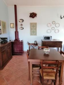 a dining room with a table and a stove at S'orrosa casa vacanze in montagna panorama stupendo Sardegna in Seùlo