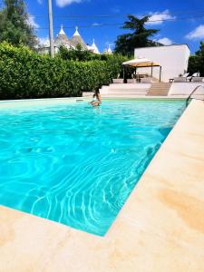 una mujer nadando en una piscina en Trulli and Pool - I Cactus, en Martina Franca