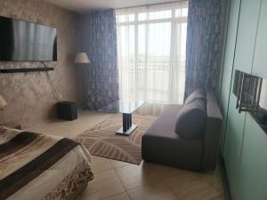 une chambre d'hôtel avec un canapé et une table en verre dans l'établissement Grand Midia Resort, Sky level apartments, à Aheloy