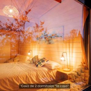 ein Schlafzimmer mit einem großen Bett mit zwei Lampen in der Unterkunft NidoGredos Cabañas Ecológicas de Diseño in El Tiemblo