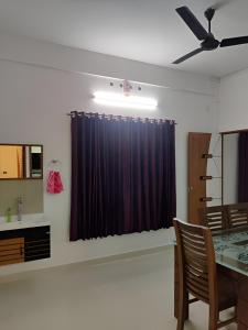 a dining room with a table and a black curtain at Spacious 2BHK Near Airport in Cochin