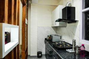 een keuken met een aanrecht met een kookplaat bij Mom Blessing Homestay in Shimla