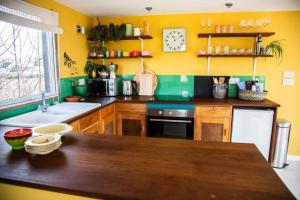 a kitchen with yellow walls and a wooden counter top at The Deckhouse, cabin with big deck nr Hay-on-Wye in Rhos-gôch