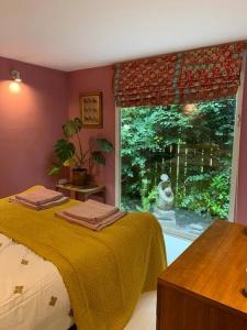 a bedroom with a bed and a large window at The Deckhouse, cabin with big deck nr Hay-on-Wye in Rhos-gôch