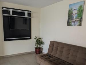 a living room with a couch and a flat screen tv at Casa Crema in Cuenca