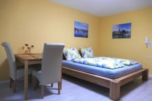 Schlafzimmer mit einem Bett und einem Holztisch mit einem Schreibtisch in der Unterkunft Ferienwohnung ML Apartment - seenah, ruhig und zentral vor der Insel Lindau in Lindau