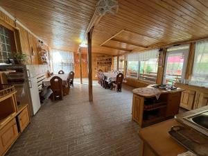 - une cuisine avec des plafonds en bois, des tables et des chaises dans l'établissement Casa Potcoava, à Lepşa