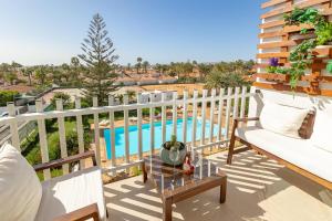 a balcony with a table and a swimming pool at Luxury Loft en Maspalomas con Terraza y Piscina in Maspalomas