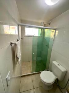 y baño con aseo y ducha acristalada. en Apartamento em Arraial do Cabo, en Arraial do Cabo