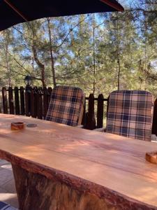 2 chaises assises autour d'une table en bois avec une table en bois dans l'établissement Kardama HideAway, à Kato Amiandos