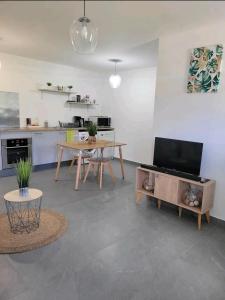 a living room with a table and a kitchen at Superbe appartement cosy neuf in Saint Martin