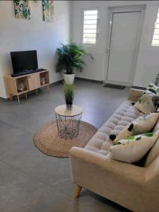 sala de estar con sofá y mesa en Superbe appartement cosy neuf, en Saint Martin