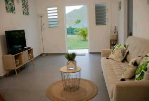 a living room with a couch and a table at Superbe appartement cosy neuf in Grand Case