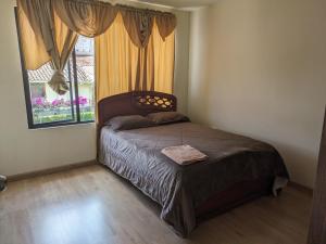 1 dormitorio con 1 cama y una ventana con cortinas en Casa Crema, en Cuenca