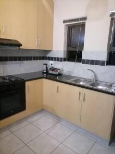 a kitchen with a sink and a stove at Peaceful Home with Sbo in Pietermaritzburg