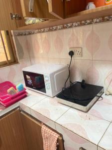 a microwave sitting on a counter in a kitchen at Chez nous in Madina